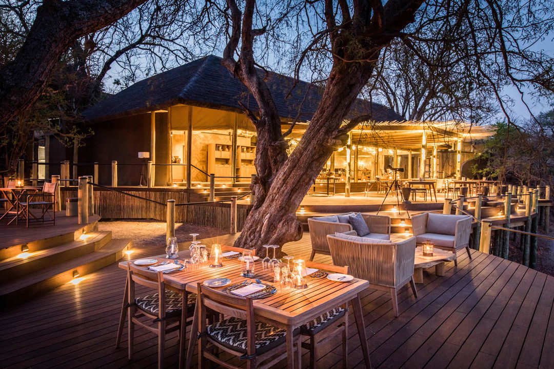 evening view of main deck set for diner by Puku Ridge Camp Zambia
