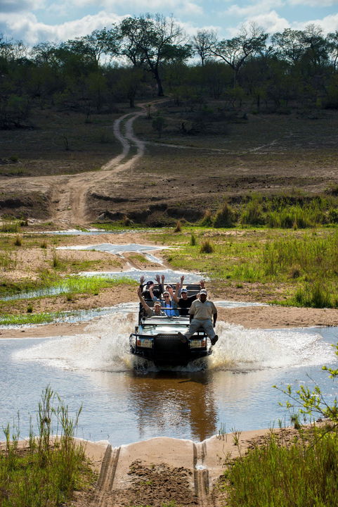 guests with guides crossing river in vehicle at &Beyond Tengile River Lodge Sabi Sands