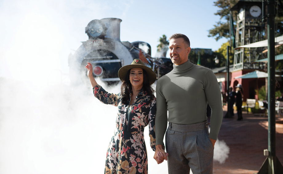 couple on platform of Rovos rail train station in front of steam locomotive couple on platform of Rovos rail train station in front of steam locomotive