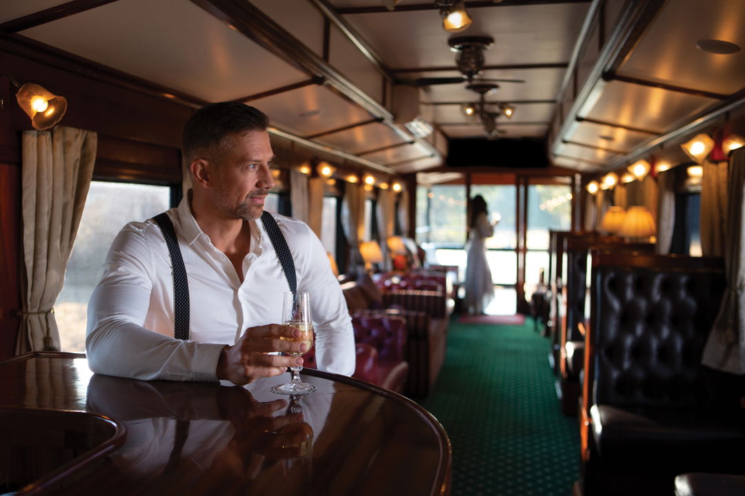 guest having drinks in the observation cart of Rovos rail luxury train safaris
