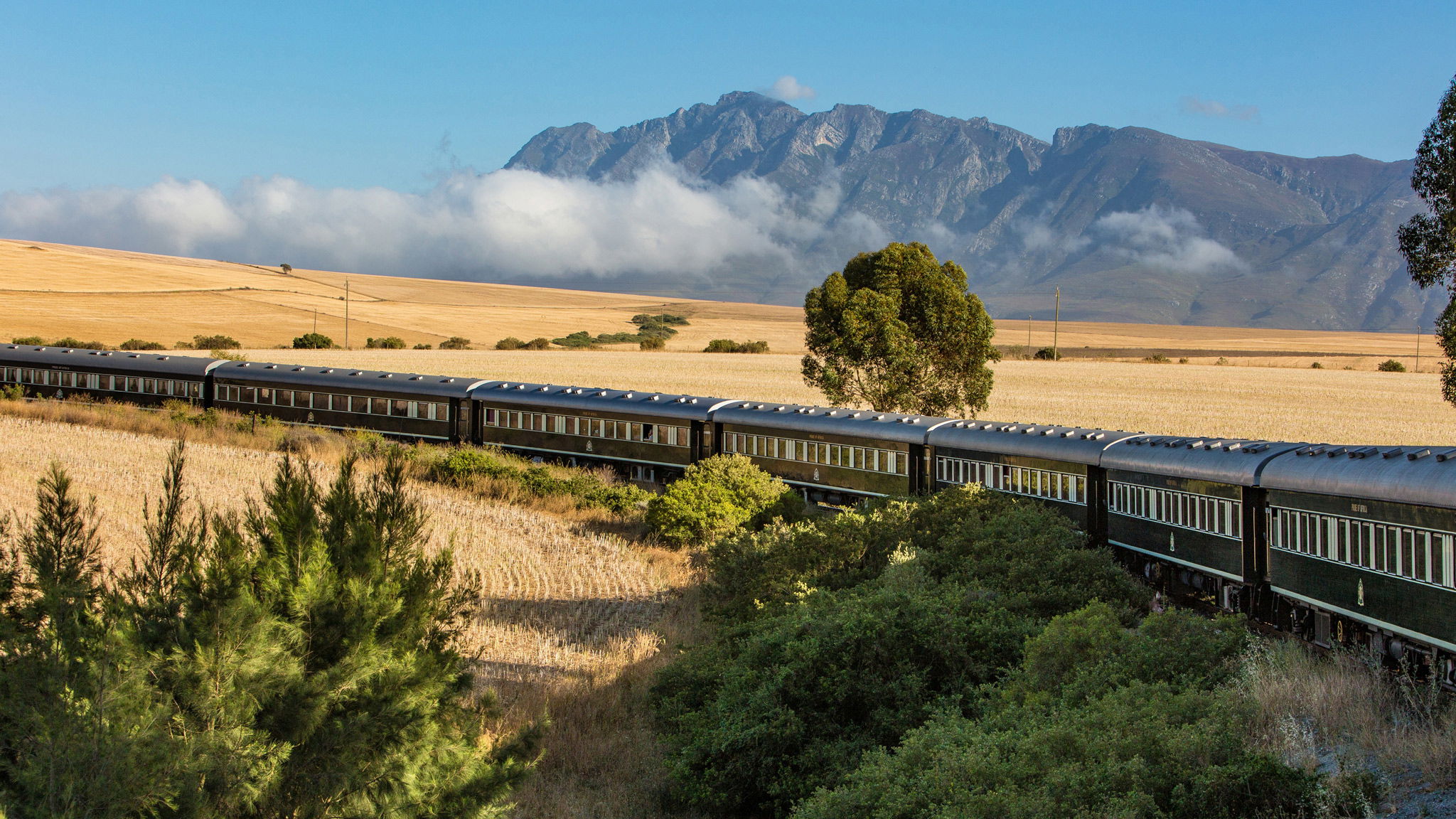  aerial view of Rovos rail train ride through south Africa with mountain in backdrop