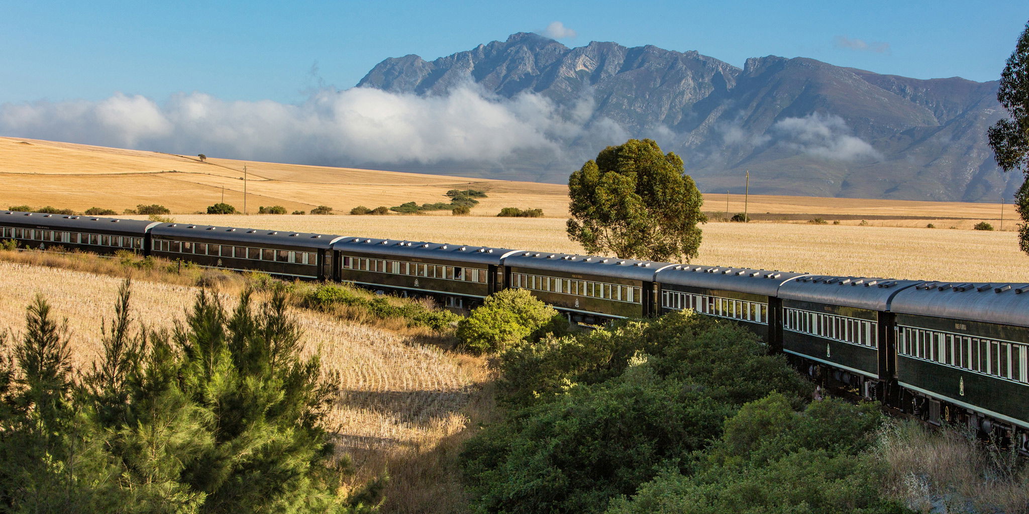  aerial view of Rovos rail train ride through south Africa with mountain in backdrop
