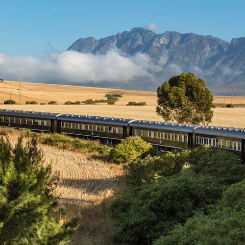 aerial view of Rovos rail train ride through south Africa with mountain in backdrop