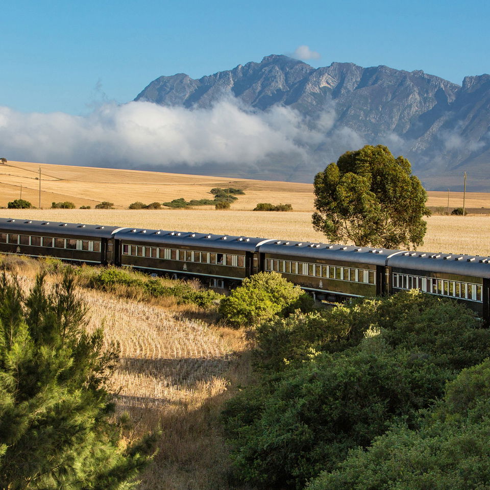  aerial view of Rovos rail train ride through south Africa with mountain in backdrop