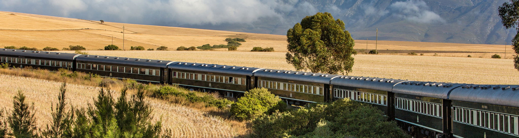  aerial view of Rovos rail train ride through south Africa with mountain in backdrop