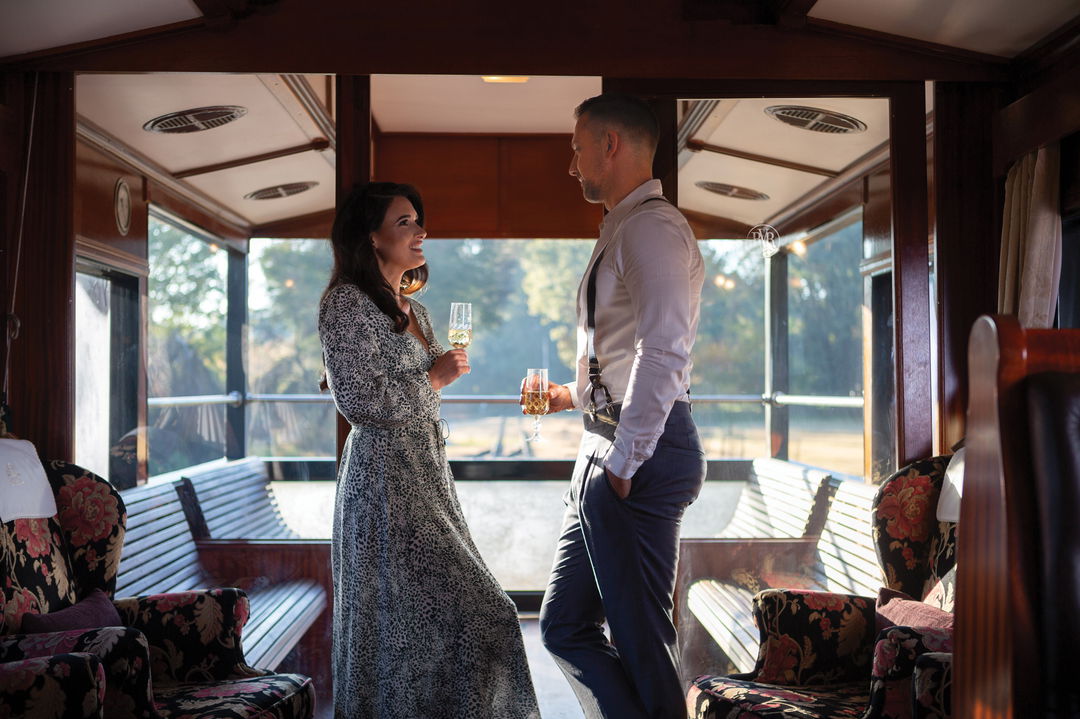 couple having drinks in the observation cart of Rovos Rail Luxury Trains