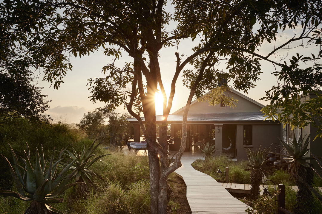 sun setting over main lodge of farmstead royal malewane