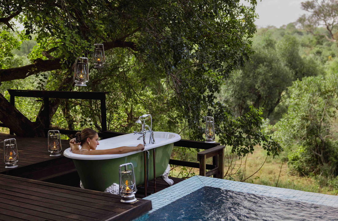 lady in bathtub on deck of royal suite at malewane lodge
