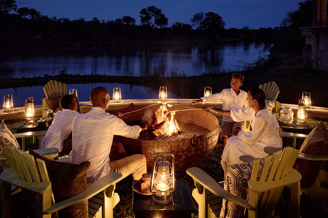 family by fireside on deck of waterside lodge royal malewane