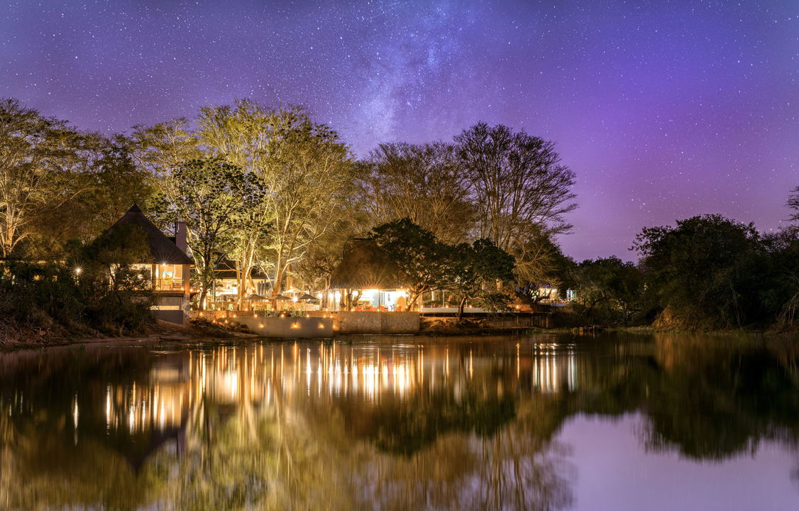 view from dam of royal malewane waterside lodge at night