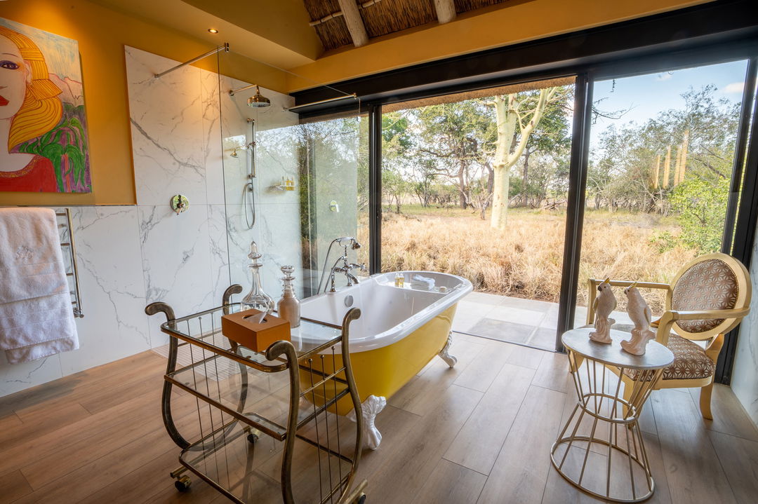 luxury suite bathroom with yellow tub at royal malewane waterside lodge