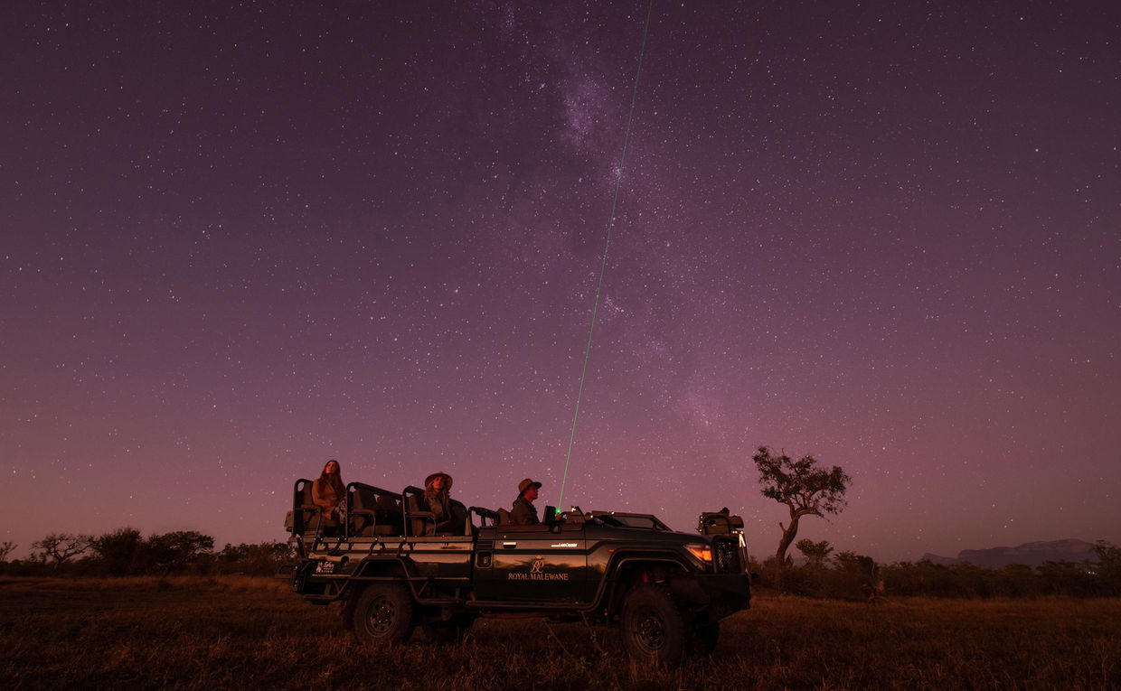 guests at royal malewane stargazing from safari vehicle at night with laser pointer