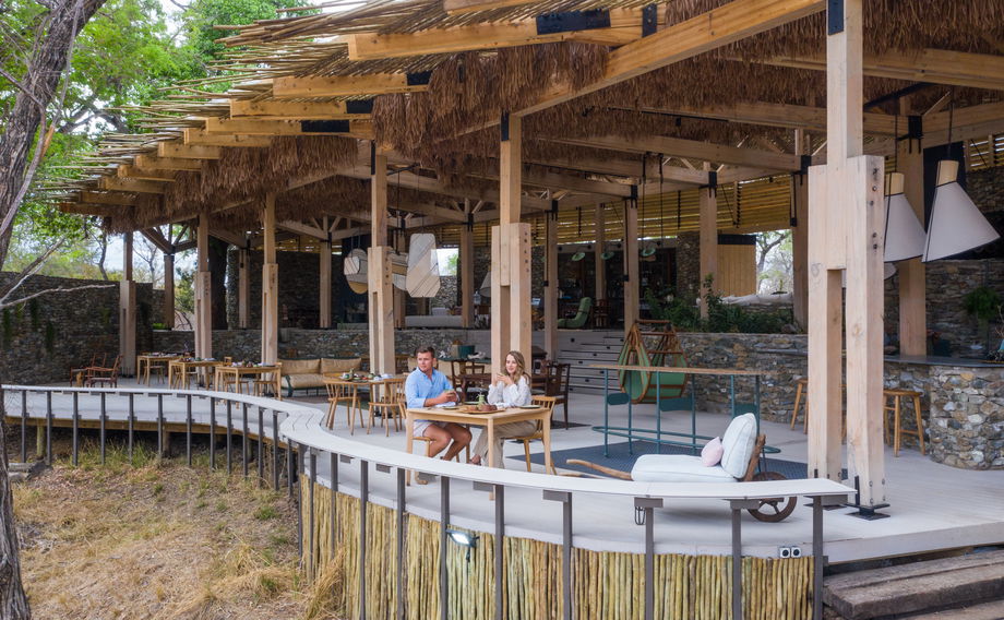 couple looking at river below from Thornybush Saseka camp main lodge deck