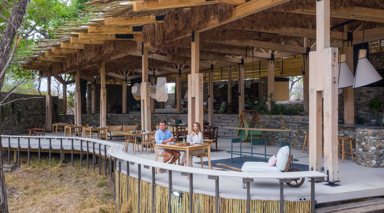 couple looking at river below from Thornybush Saseka camp main lodge deck