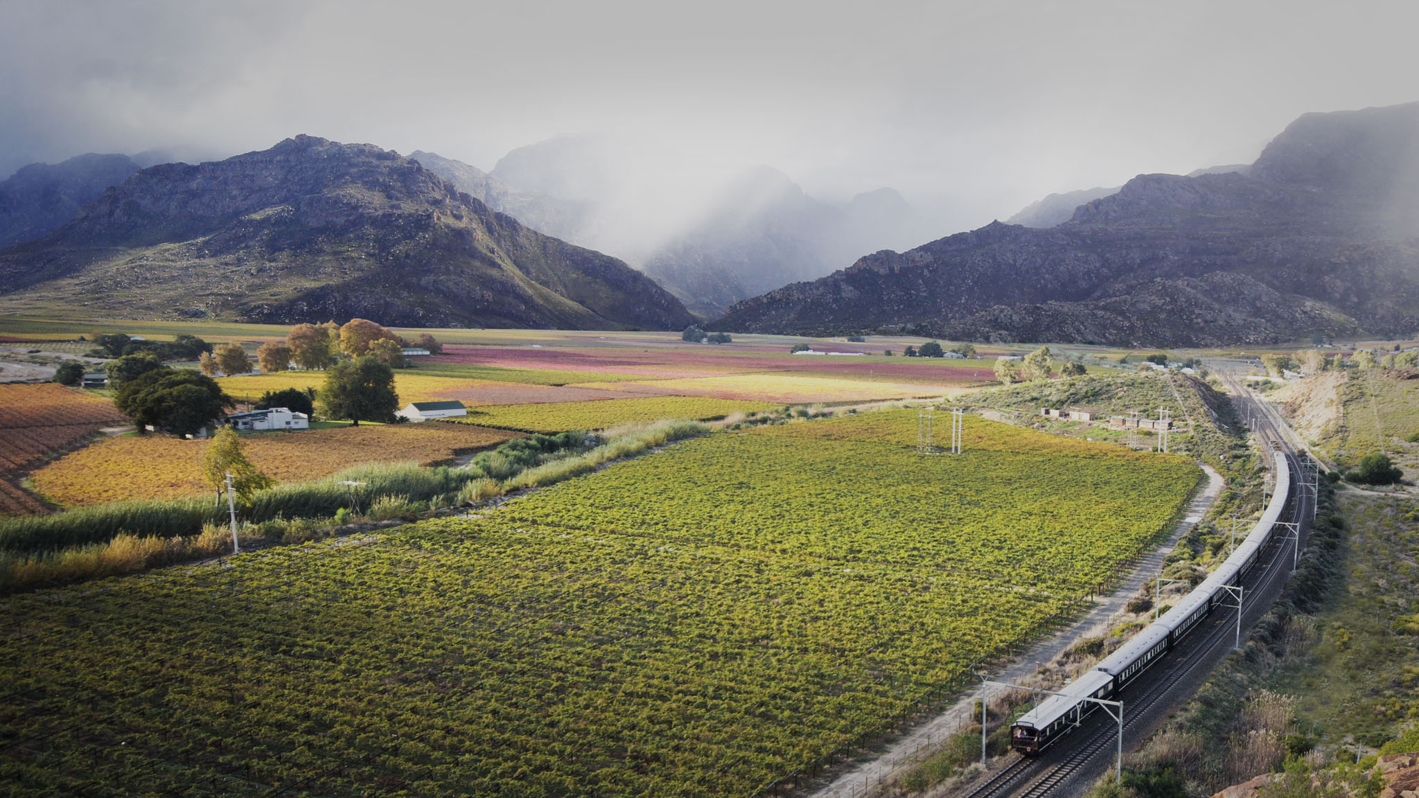 aerial view of countryside with train traveling at Rovos Rail