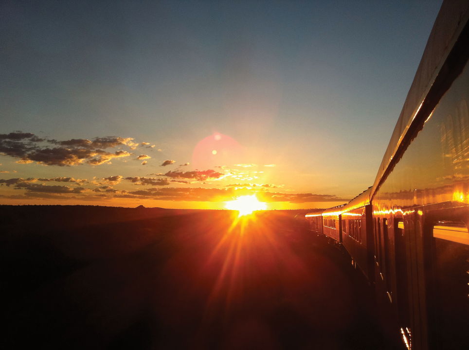 sun rays on side of train on track at Rovos Rail