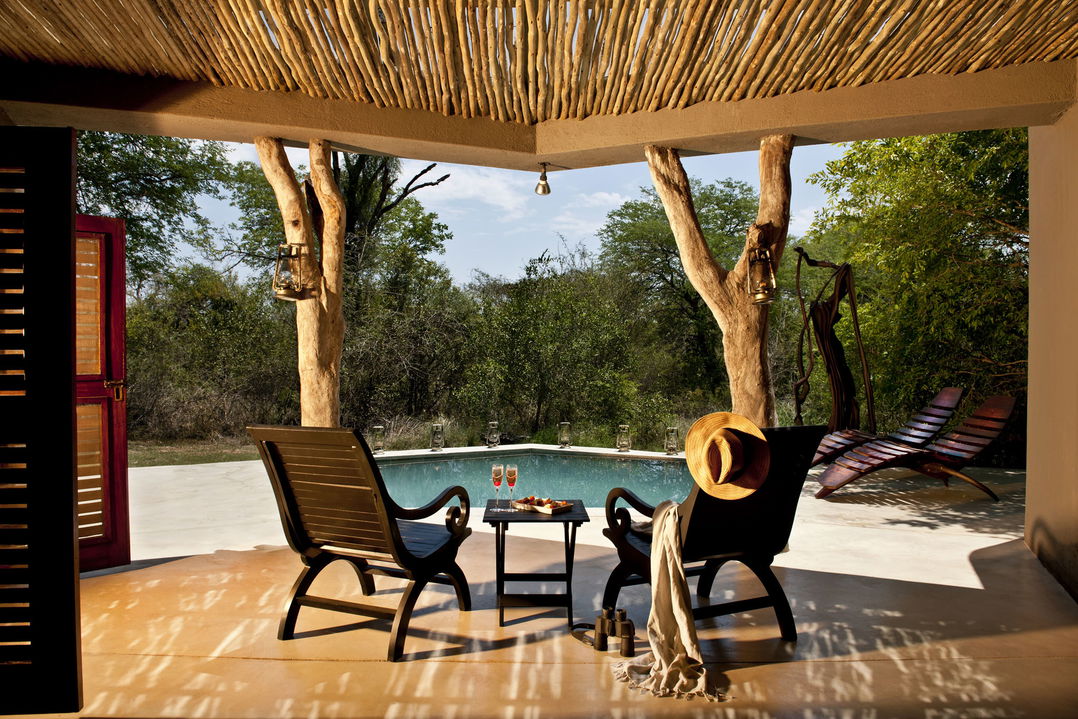 two chairs on pool deck by mendleve suite of sabi sabi bush lodge