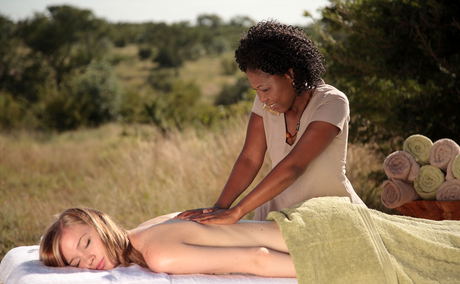 lady guest getting messaged on bed outside of amani spa at sabi sabi game lodges