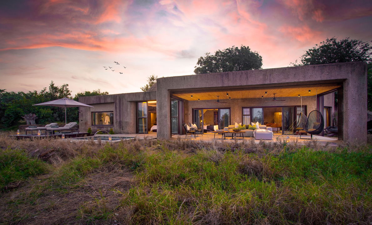 exterior view of sabi sabi earth lodge at sunset
