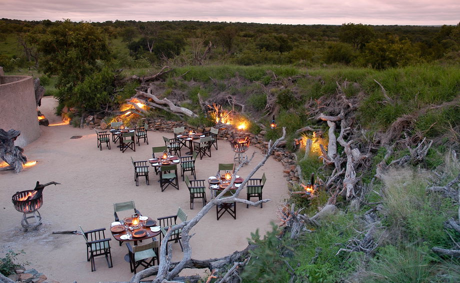 aerial view of boma at sabi sabi earth lodge at sunset with dinner tables set