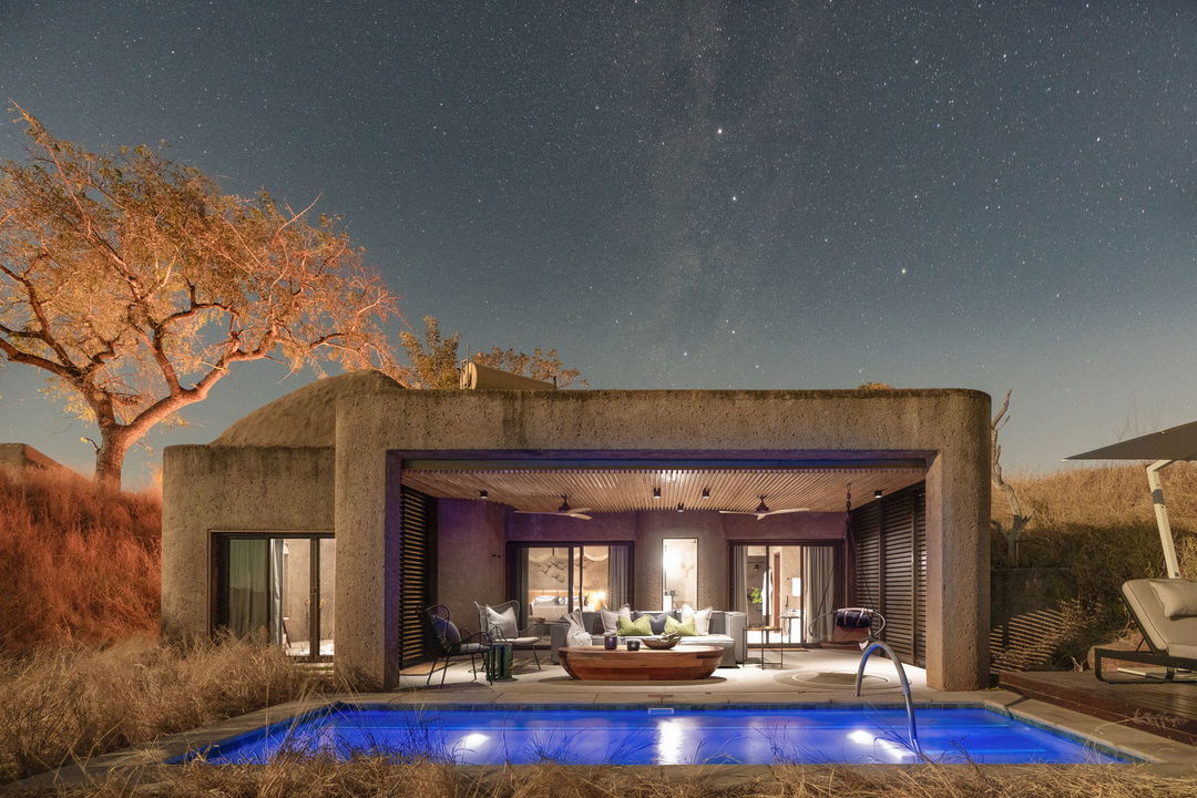 evening view from bush of sabi sabi earth lodge showing iluminated pool