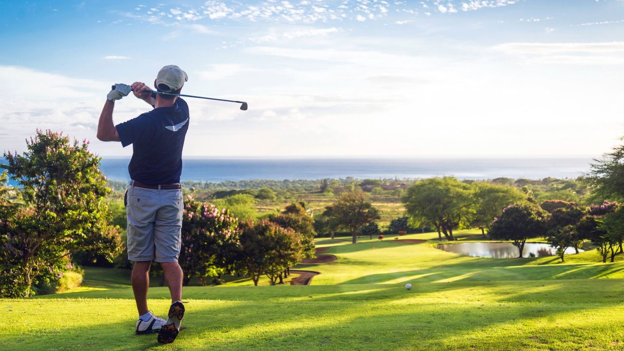 golfer teeing off with bush view in background in south Africa