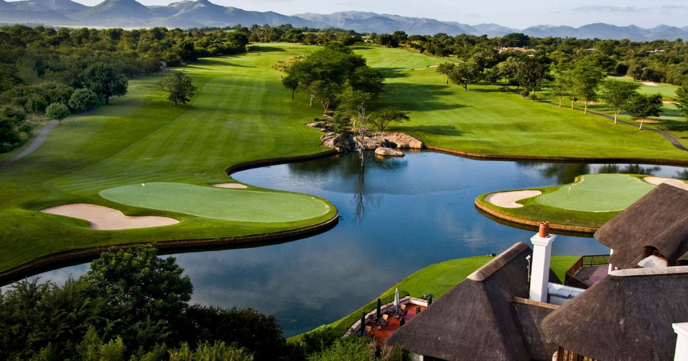 aerial view of fairways and green with a dam on leopard creek golf course 