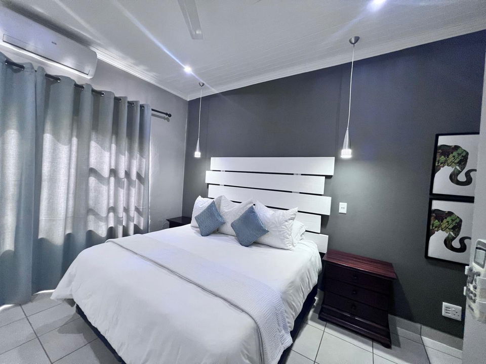 interior of luxury room with double bed white linen at secrets VIP safari lodge Komatipoort