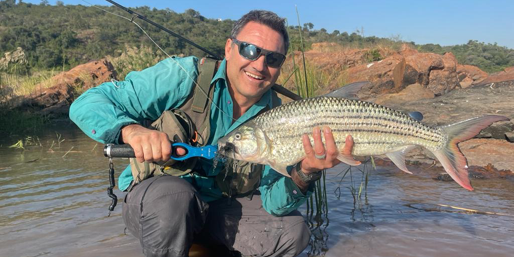 fly fisherman holding a big tigerfish caught in Komati river on fly