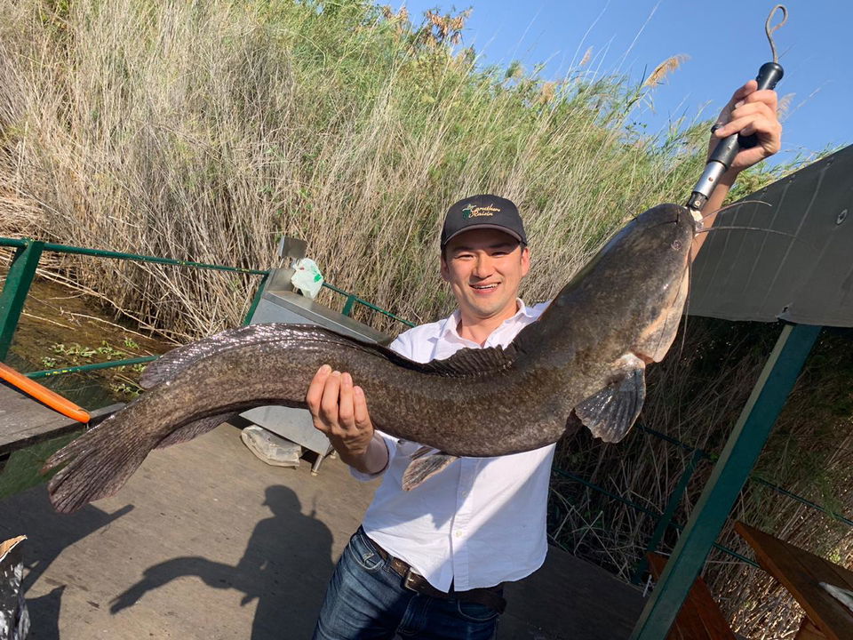young man showing off a big barbel caught in the Komati river