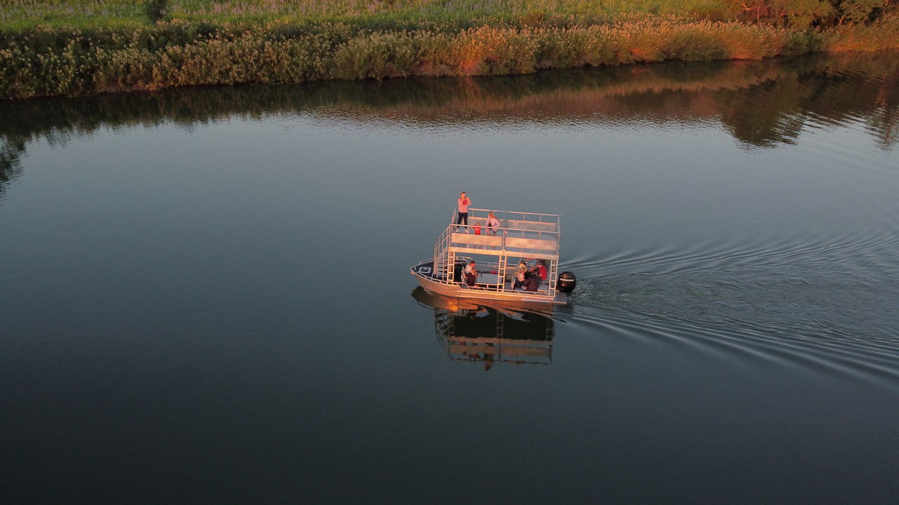 arial view of a barge  with fishermen cruising down the Komati river