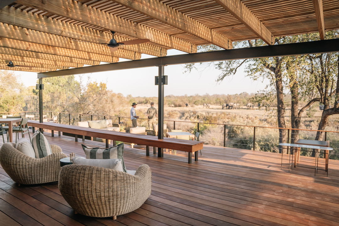 Main area and deck at Simbambili Thornybush luxury safari lodge with elephants in background