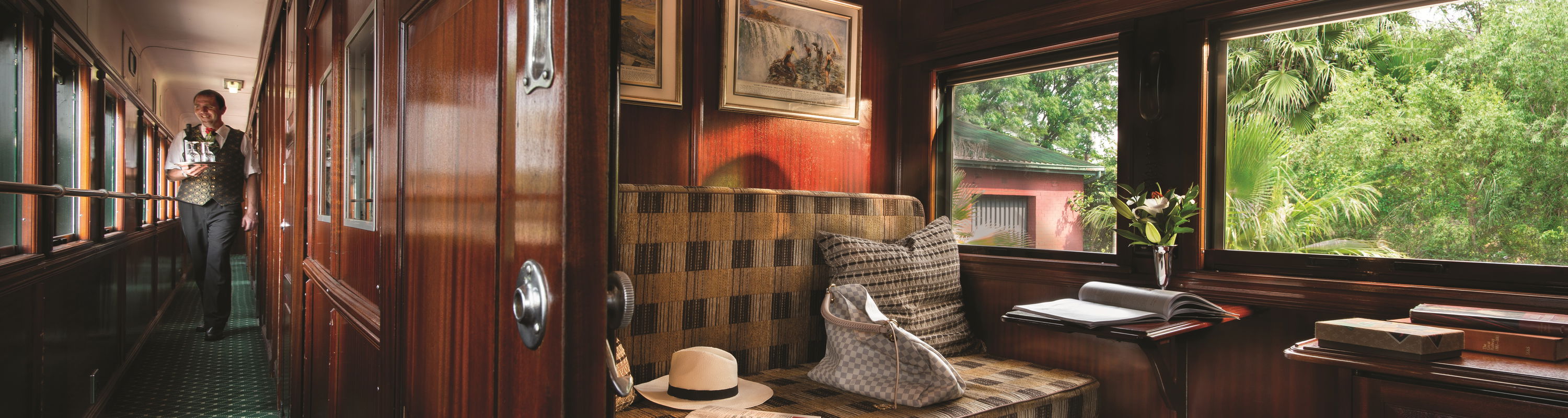 interior of Rovos rail train cabin with bench and safari hat with luggage 