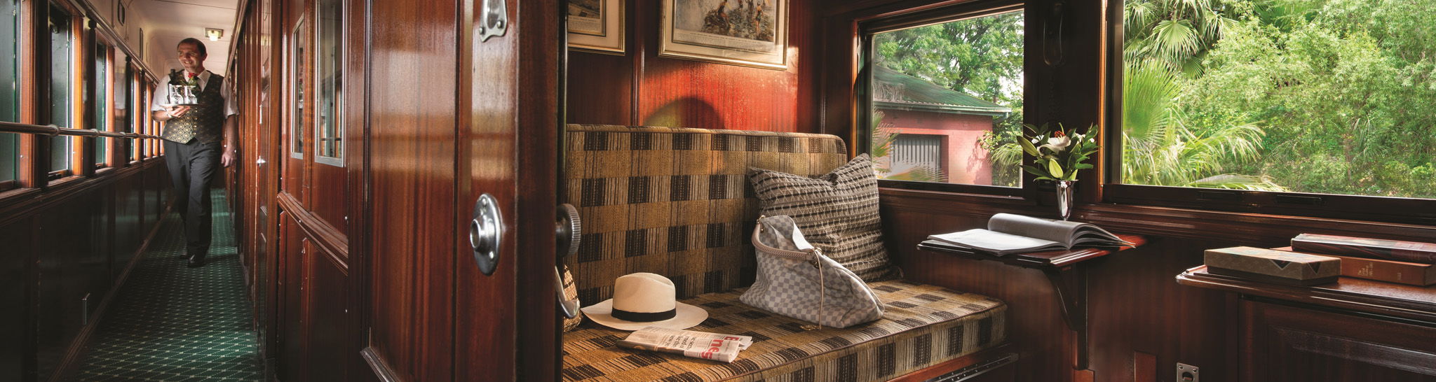 interior of Rovos rail train cabin with bench and safari hat with luggage 