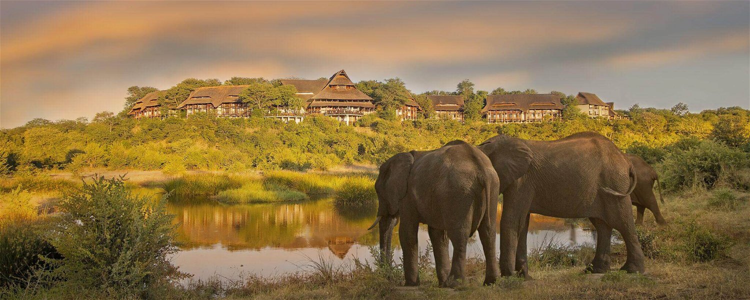 Secrets VIP Travel Safari Lodge overlooking watering hole with Elephants