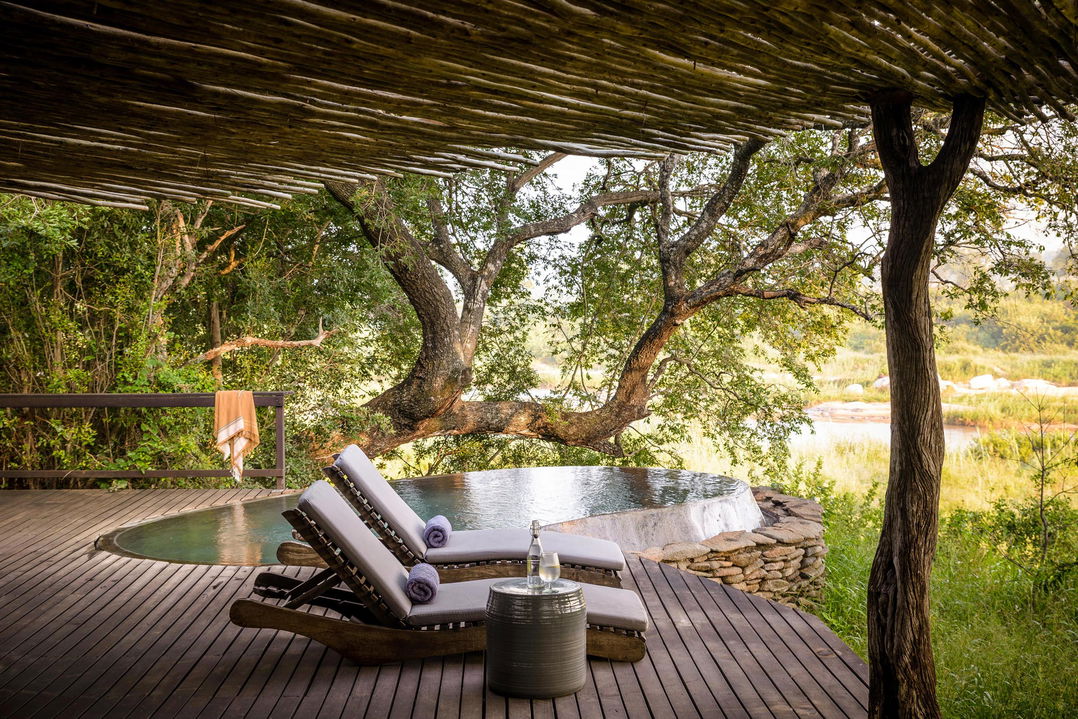 chairs on deck by splash pool at singita boulders lodge