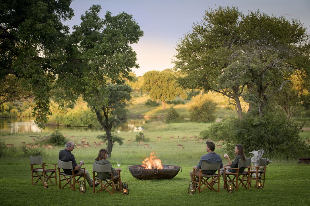 guests relaxing at fireside outside singita castleton lodge