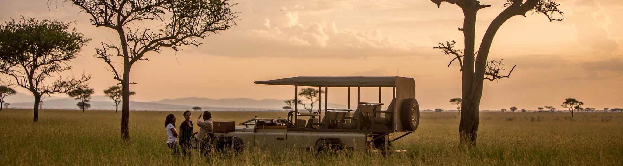 game drive vehicle at sunset in Serengeti with sundowners at Singita Faru Faru lodge Serengeti