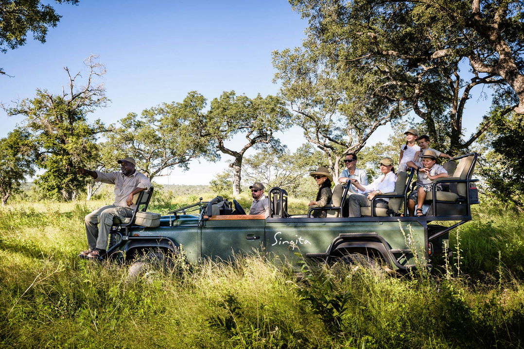 guide showing guests wildlife on a game drive at singita sabi sand