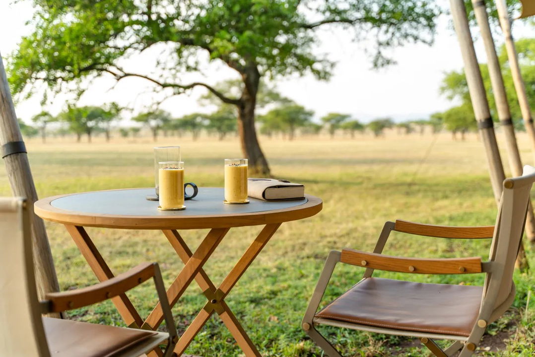 table with drinks on lawn of Singita Sabora Tented Camp Serengeti 