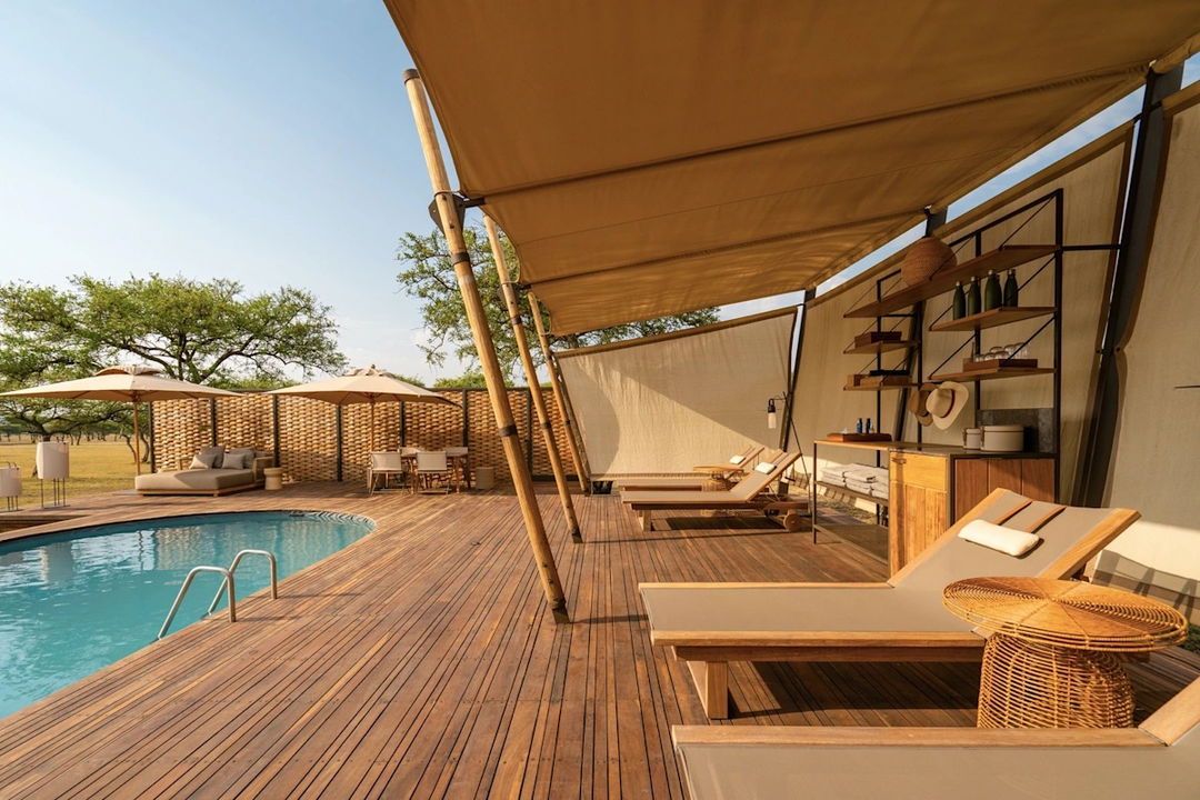 pool with deck loungers and big sala at Singita Sabora Tented Camp Serengeti 