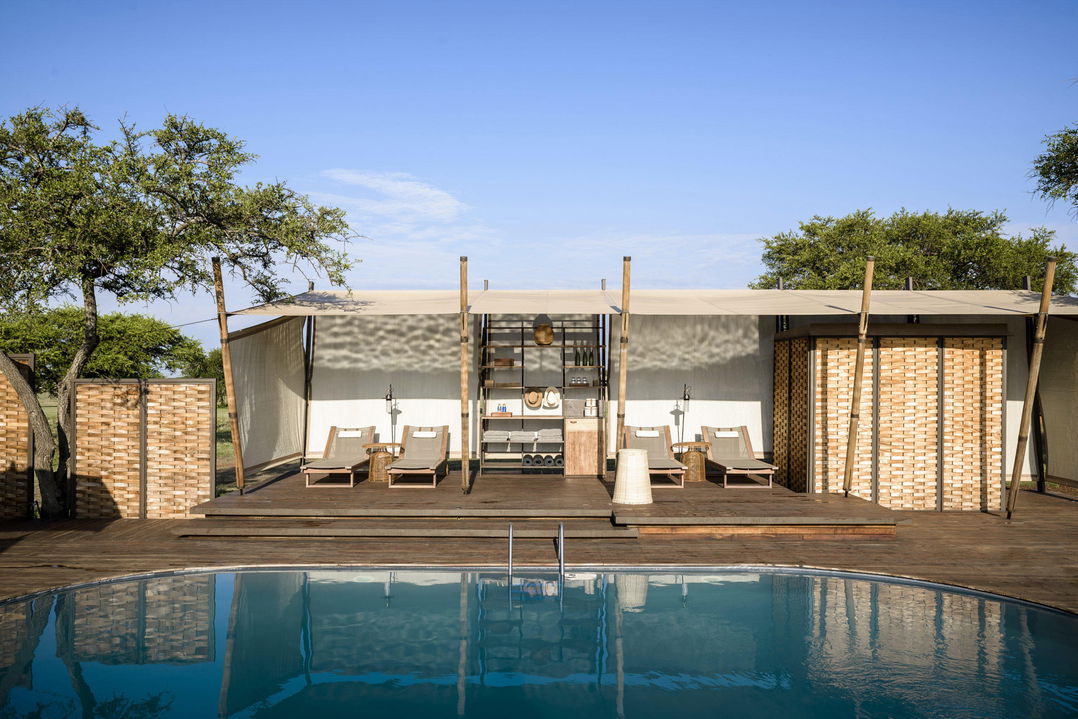 view of the main pool with loungers and sala at Singita Sabora Tented Camp Serengeti 