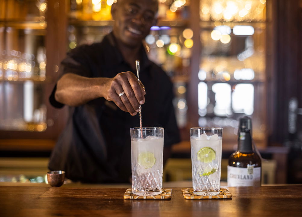 barman stirring cocktails at the bar of Singita Sasakwa lodge in Serengeti
