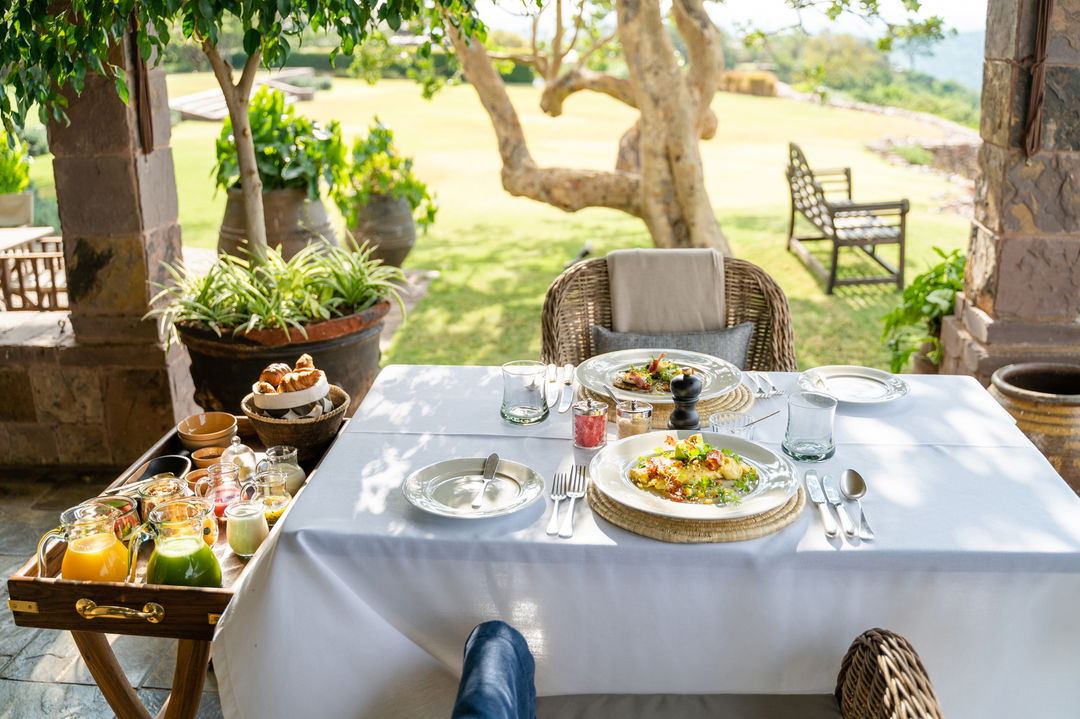 dining setting under trees at Singita Sasakwa lodge in Serengeti