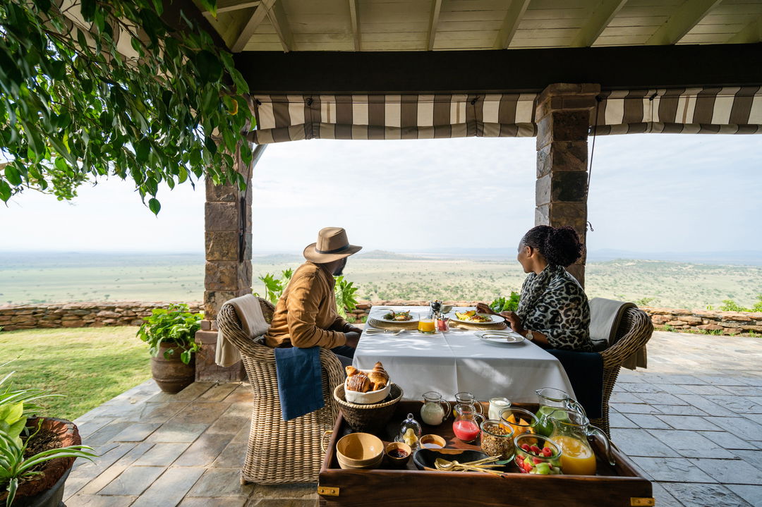 couple having private lunch on deck of suite at Singita Sasakwa lodge in Serengeti