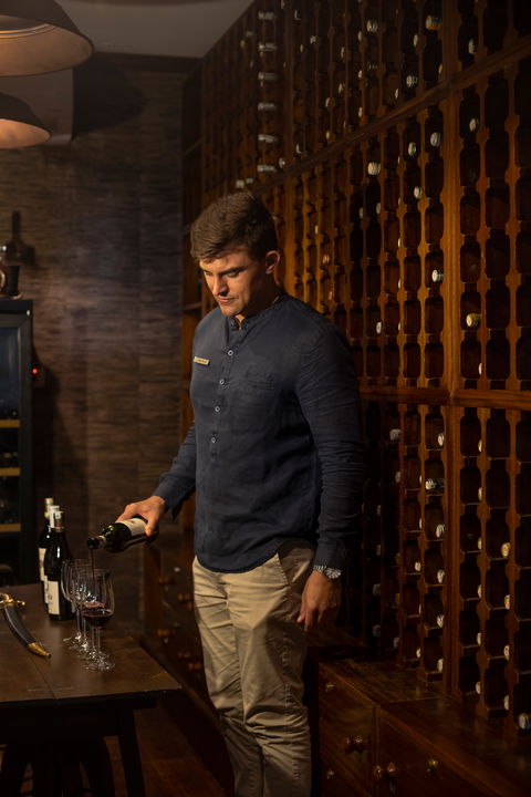 sommelier in cellar getting ready for wine tasting at Singita Sasakwa lodge in Serengeti