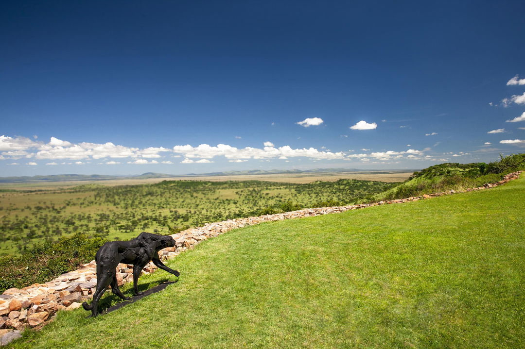 gardens with statue overlooking Serengeti plains at Singita Sasakwa lodge 