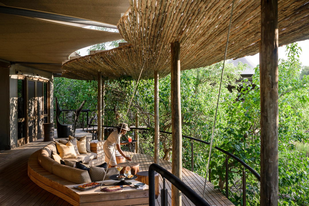 Staff serving drinks on viewing deck at Xigera lodge Botswana