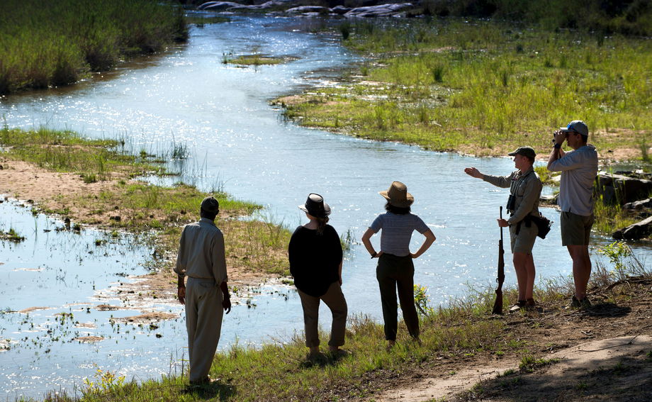 guide talking to guests on riverbank at &Beyond Tengile River Lodge Sabi Sands