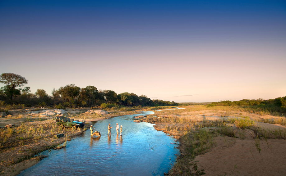 guests in river with sundowners at &Beyond Tengile River Lodge Sabi Sands